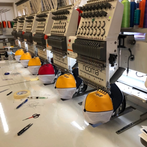 Embroidery machines stitching custom hats